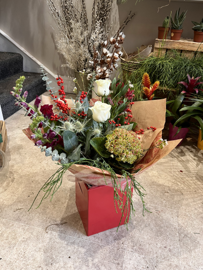 Christmas Florist Choice Hand-Tied - A festive hand-tied filled with the seasonal flowers, perfectly wrapped by the local florist and delivered in water.